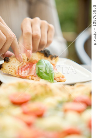 カフェでピザを食べる女性 カフェでピザを食べる女性 109765938
