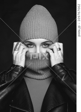 black and white portrait of beautiful girl in balaclava and leather coat 109767002