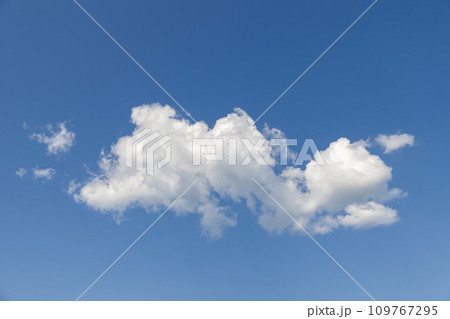 Large cumulus cloud brilliantly lit against a blue sky, creating a striking picturesque sky scene 109767295