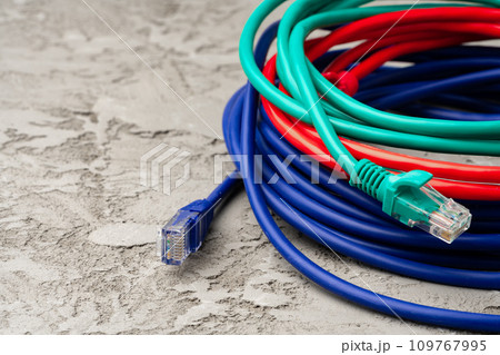 Colored network cable patch-cord on gray textured background Colored network cable patch-cord on gray textured background 109767995