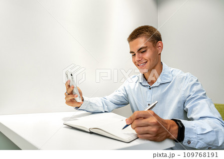 Young handsome entrepreneur using his mobile phone in the office 109768191