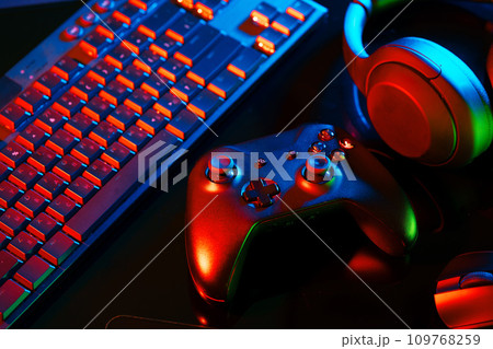 Headphones, joystick and computer keyboard on black table 109768259