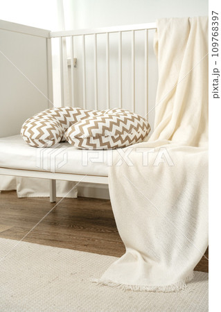 White wooden baby crib with pillow in nursery room 109768397