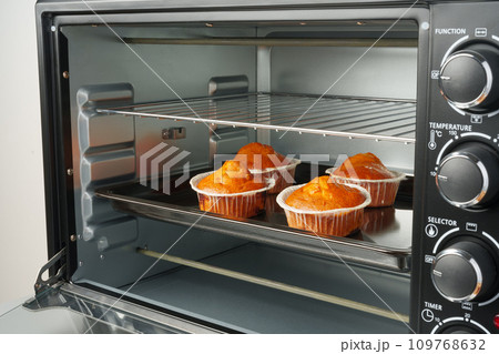 Electric mini oven and baked hot muffins close up 109768632