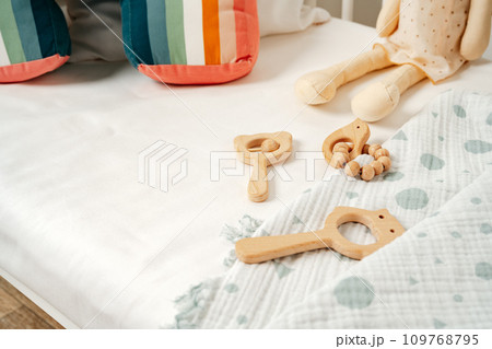 Toys and muslin soft blanket in baby bed close up 109768795