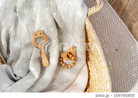 Muslin blanket and wooden toys in baby cradle Muslin blanket and wooden toys in baby cradle 109768808