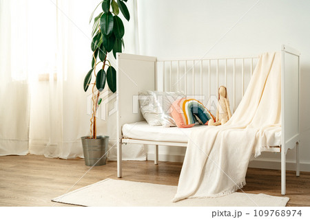 White wooden baby crib in nursery room White wooden baby crib in nursery room 109768974