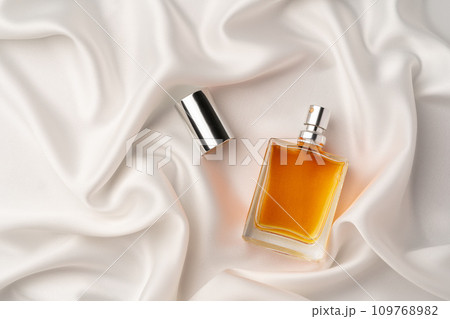 Glass bottle with serum or cosmetic oil on silk fabric background 109768982