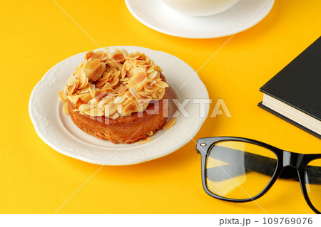 Tartlet with almond petals and cup of coffee on yellow background 109769076