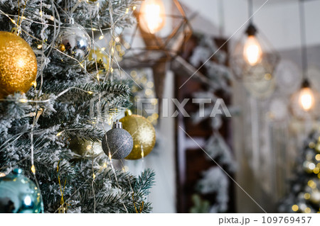 Christmas tree bulbs with yellow garlands, xmas tree with decorative bulbs. 109769457