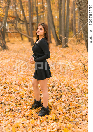 Close up portrait of pretty indian young woman enjoying warm autumn sunny day vacation outdoors. Generation z and gen z concept. Fall Season 109769550