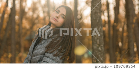 Banner beautiful indian woman generation z relaxing and feeling nature at autumn park in fall season copy space. Diversity and gen z youth 109769554