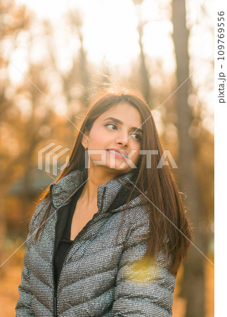 Close up portrait of pretty indian young woman enjoying warm autumn sunny day vacation outdoors copy space mockup. Generation z and gen z concept. Fall Season 109769556
