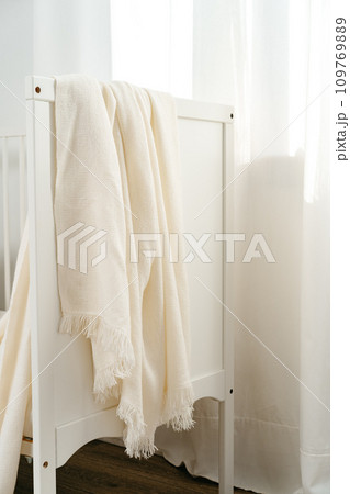 Soft cotton blanket hanging on baby's bed Soft cotton blanket hanging on baby's bed 109769889