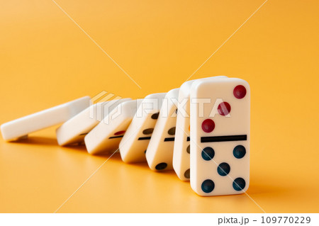 Row of domino tiles on yellow studio background Row of domino tiles on yellow studio background 109770229