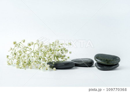 Spa stones and flowers on the white background Spa stones and flowers on the white background 109770368