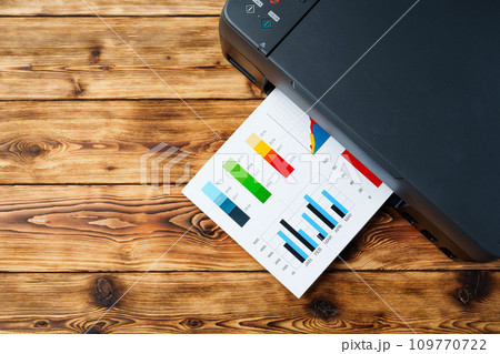 Modern laser printer with paper on wooden background 109770722