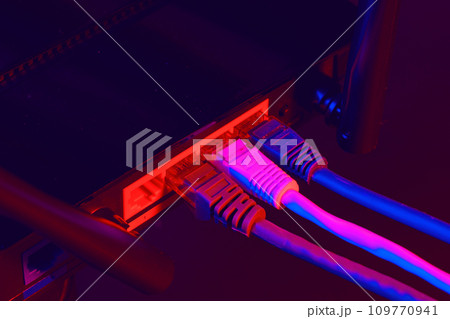 Cables plugged in a Wi-Fi router on dark background Cables plugged in a Wi-Fi router on dark background 109770941