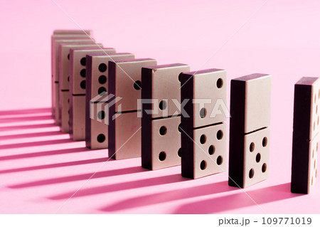 Row of domino tiles on pink studio background 109771019