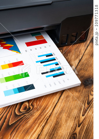 Modern laser printer with paper on wooden background 109771318