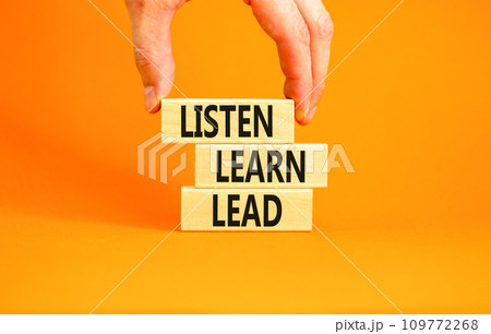 Listen learn lead symbol. Concept word Listen Learn Lead on beautiful wooden block. Businessman hand. Beautiful orange table orange background. Business education listen learn lead concept. Copy space Listen learn lead symbol. Concept word Listen Learn Lead on beautiful wooden block. Businessman hand. Beautiful orange table orange background. Business education listen learn lead concept. Copy space 109772268
