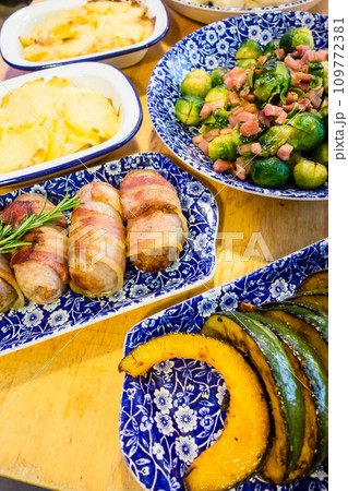 青色のお皿に盛られたクリスマスディナー料理 ソーセージと芽キャベツとポテトパイ 青色のお皿に盛られたクリスマスディナー料理 ソーセージと芽キャベツとポテトパイ 109772381