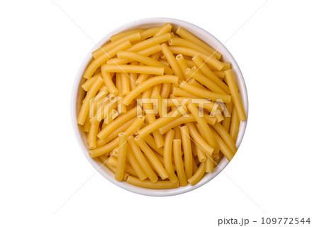 Raw whole grain wheat pasta with salt and spices in a ceramic plate 109772544