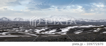 Iceland highlands autumn ultrawide view. Lava fields of volcanic sand in foreground. Hrauneyjalon lake and volkanic snow covered mountains in far. Iceland highlands autumn ultrawide view. Lava fields of volcanic sand in foreground. Hrauneyjalon lake and volkanic snow covered mountains in far. 109772870
