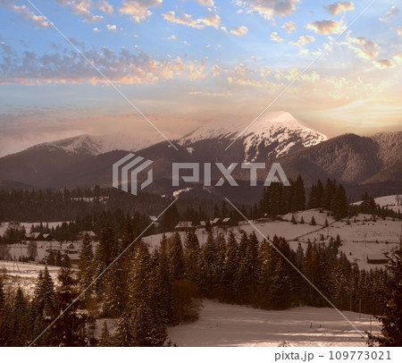 Winter remote alpine mountain village outskirts, countryside hills, groves and farmlands. Winter remote alpine mountain village outskirts, countryside hills, groves and farmlands. 109773021