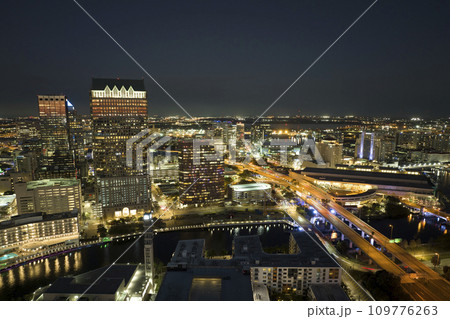 View from above of brightly illuminated high skyscraper buildings and moving traffic in downtown district of Tampa city in Florida, USA. American megapolis with business financial district at night 109776263