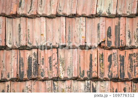 Closeup surface of old weathered ceramic tiles covering building roof Closeup surface of old weathered ceramic tiles covering building roof 109776312