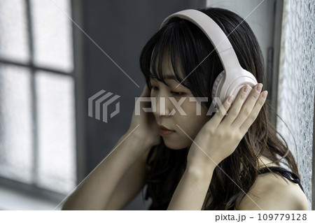 ヘッドホンで音楽を聴く若い女性 ヘッドホンで音楽を聴く若い女性 109779128