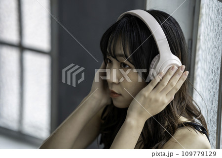 ヘッドホンで音楽を聴く若い女性 ヘッドホンで音楽を聴く若い女性 109779129