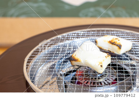 石油ストーブで餅を焼く様子 109779412