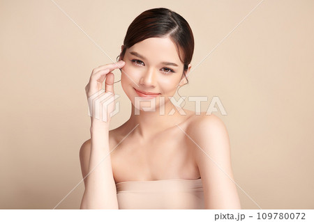 Beautiful young asian woman with clean fresh skin on beige background, Face care, Facial treatment, Cosmetology, beauty and spa, Asian women portrait. 109780072