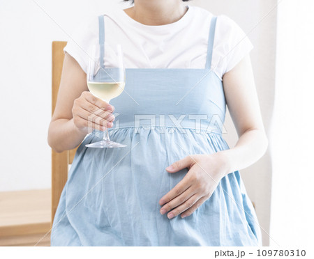 ワインがはいったワイングラスを持った妊婦女性 109780310