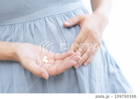 妊婦の女性が薬を摂取するイメージ 妊婦の女性が薬を摂取するイメージ 109780386