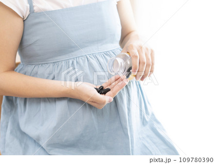 妊婦の女性がサプリメントを摂取するイメージ 109780390