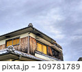 空き家の崩れ落ちた二階の屋根の一部と曇り空のある風景 109781789