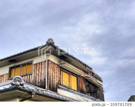 空き家の崩れ落ちた二階の屋根の一部と曇り空のある風景 空き家の崩れ落ちた二階の屋根の一部と曇り空のある風景 109781789
