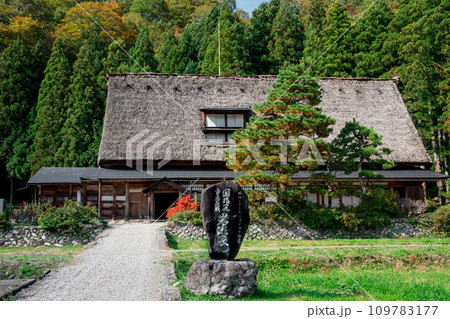 紅葉に包まれたかやぶき屋根の古民家 109783177