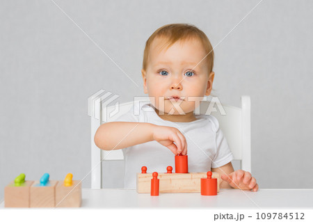 Cute girl likes wooden toys. Child plays with constructor Cute girl likes wooden toys. Child plays with constructor 109784512