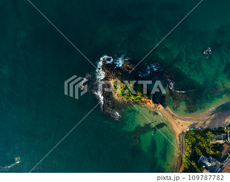 Aerial view of tranquil coastal vista with lush greenery and azure waters, ideal for travel brochures and postcards promoting serene vacations and tropical getaways. Parrot rock island in Sri Lanka. Aerial view of tranquil coastal vista with lush greenery and azure waters, ideal for travel brochures and postcards promoting serene vacations and tropical getaways. Parrot rock island in Sri Lanka. 109787782