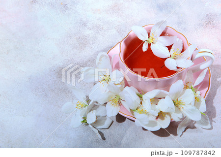 A beautiful pink cup with hot tea and white flowers all around. Valentine's Day, Happy Women's Day. Copy space. 109787842