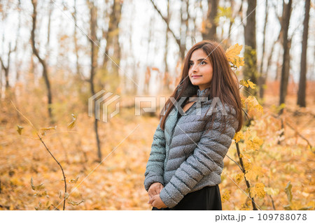 Close-up portrait of diversity young beautiful confident Indian Asian woman in fall outdoor copy space mockup. Happy and natural smiling female. Generation z and gen z youth concept 109788078