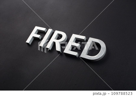 the word fired laid with silver metal letters on flat black surface 109788523