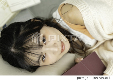 本を抱えて寝転ぶ若い女性 本を抱えて寝転ぶ若い女性 109789361