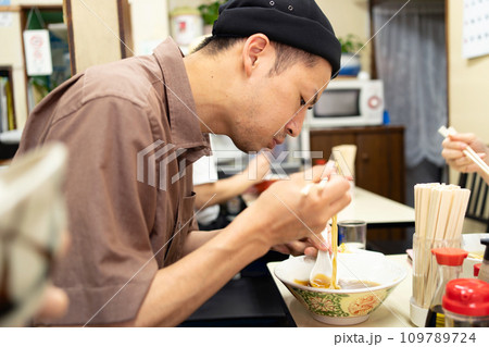 町中華でラーメンを食べる男性 109789724