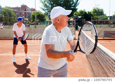 Grandfather and grandson playing tennis court 109790745