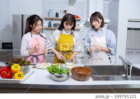 キッチンでサンドイッチを作る女性3人 キッチンでサンドイッチを作る女性3人 109791121